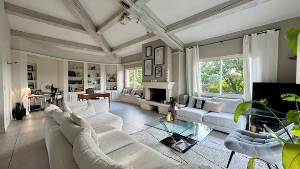 A spacious living room with a fireplace, a sofa set, a coffee table, and a television.