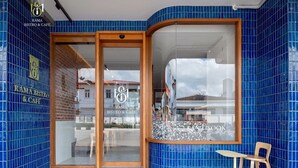 A bistro and cafe with blue-tiled walls and a wooden-framed entrance. - Santisookmidtown (Pattani)