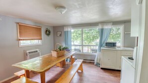 A kitchen with a wooden table, bench, and white appliances.