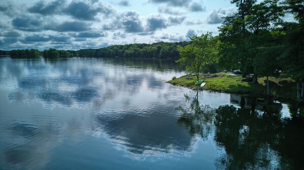 Un lago tranquilo con orilla cubierta de hierba y árboles.