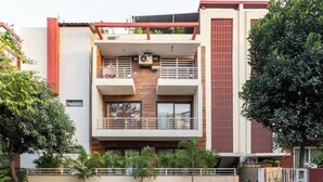 A modern two-story residential building with a balcony, a small garden area, and a paved driveway. - TIM Sector 51, ARTEMIS HOSPITAL 1 min walk, FORTIS & MEDANTA 4 mins drive (Gurugram)
