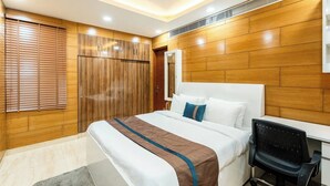 A modern bedroom with a large bed, a desk, and a chair. - TIM Sector 51, ARTEMIS HOSPITAL 1 min walk, FORTIS & MEDANTA 4 mins drive (Gurugram)