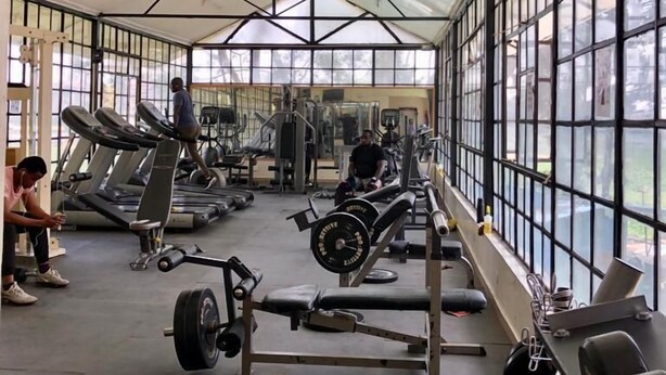 Een fitnessruimte met loopbanden, krachtapparaten en losse gewichten.
