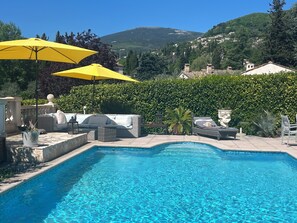A swimming pool with a view of a hillside, surrounded by greenery and outdoor furniture. - Villa Bibaou: 1 bedroom 2P ; a haven of peace between sea, mountains (Vence)