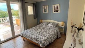 A bedroom with a bed, a nightstand, a lamp, and a decorative bird sculpture.