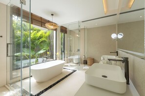 Une salle de bain moderne avec une baignoire sur pieds, une douche à parois de verre et un grand miroir.