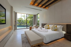 A modern bedroom with a large bed, a bench, a TV, and a view of a pool.