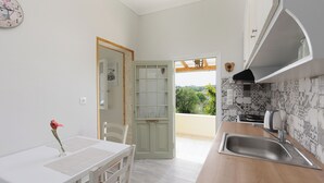 Una cocina moderna con encimera de madera, pileta de acero inoxidable y vista a áreas verdes.