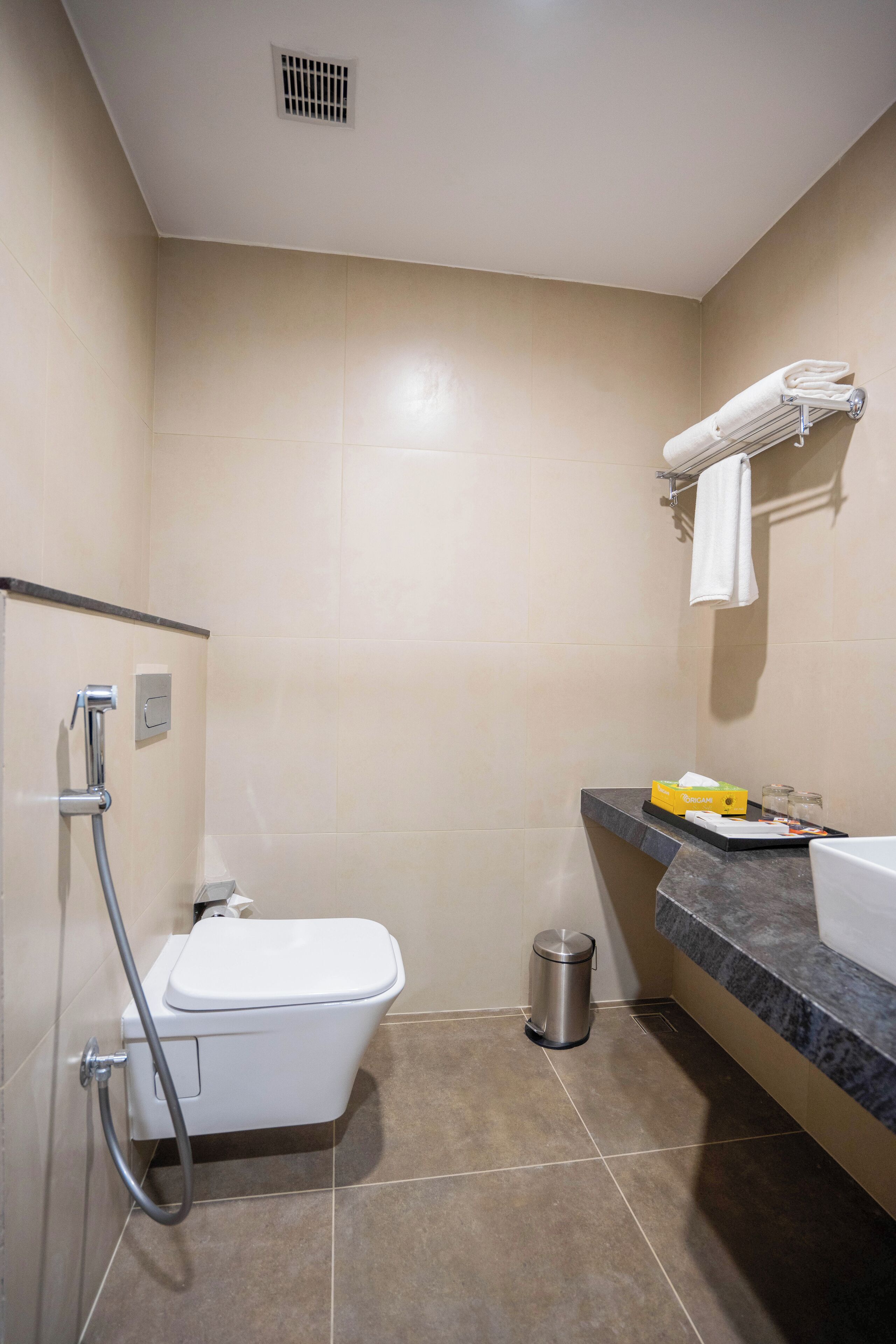 A modern bathroom with a shower, toilet, and sink.