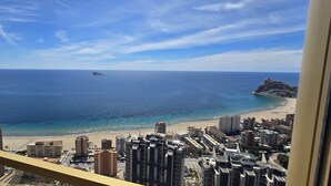 A coastal cityscape with a beach, buildings, and a distant island. - INTEMPO (2 BEDROOMS) (Benidorm)