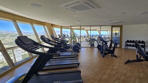 A gym with treadmills, exercise bikes, and weight machines, large windows with a city view. - INTEMPO (2 BEDROOMS) (Benidorm)