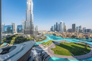 A modern cityscape with a prominent skyscraper, a waterfront area, and a large green park. - Burj & Fountain View Retreat (Dubai)
