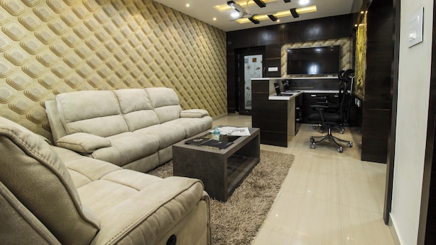 A modern living room with a beige sofa, a coffee table, and a TV in the background. - SR Boutique Stay  (Coimbatore)