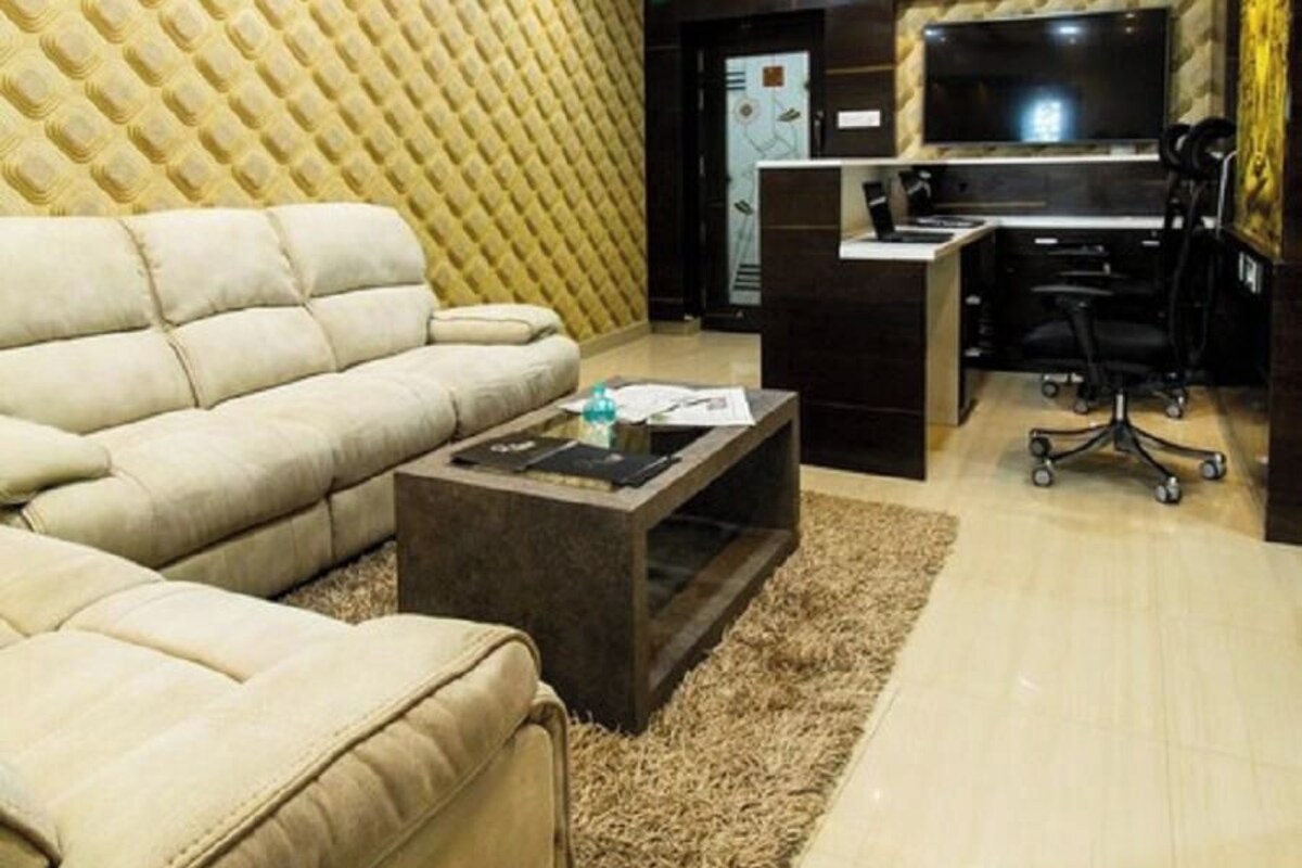 Ein Wohnzimmer mit einer Couch, einem Couchtisch, einem Fernseher, einem Schreibtisch und einem Sessel.