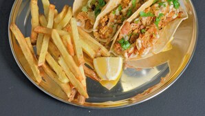 A plate with two tacos and a side of French fries. - Midtown Premium (Saskatoon)