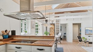 A modern kitchen with a central island, white cabinetry, and a stainless steel range hood. - "Veljan" - 1.2km from the sea by Interhome (Vig)