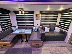 Un espace de vie compact comprenant un canapé, une petite table et un banc.