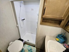 Een haardroger, handdoeken, zeep, toiletpapier