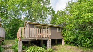A cabin with a wooden deck, a small porch, and a window. - Serene Sydenham Lake Cottage - Fishing paradise (Perth Road)