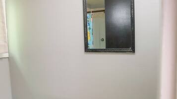 A bathroom with a toilet, sink, and mirror.