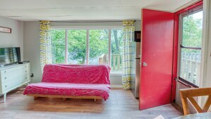 A bedroom with a bed, a dresser, a television, and a window with curtains. - Serene Sydenham Lake Cottage - Fishing paradise (Perth Road)