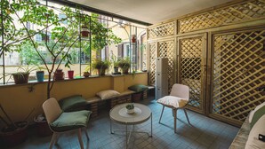 A balcony with a seating area, potted plants, and a view of the city. - Habitat 42 Roman Stay (Rome)