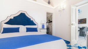 A bedroom with a large bed, a desk, and a chair. - King Apartment - Positano Center (Positano)