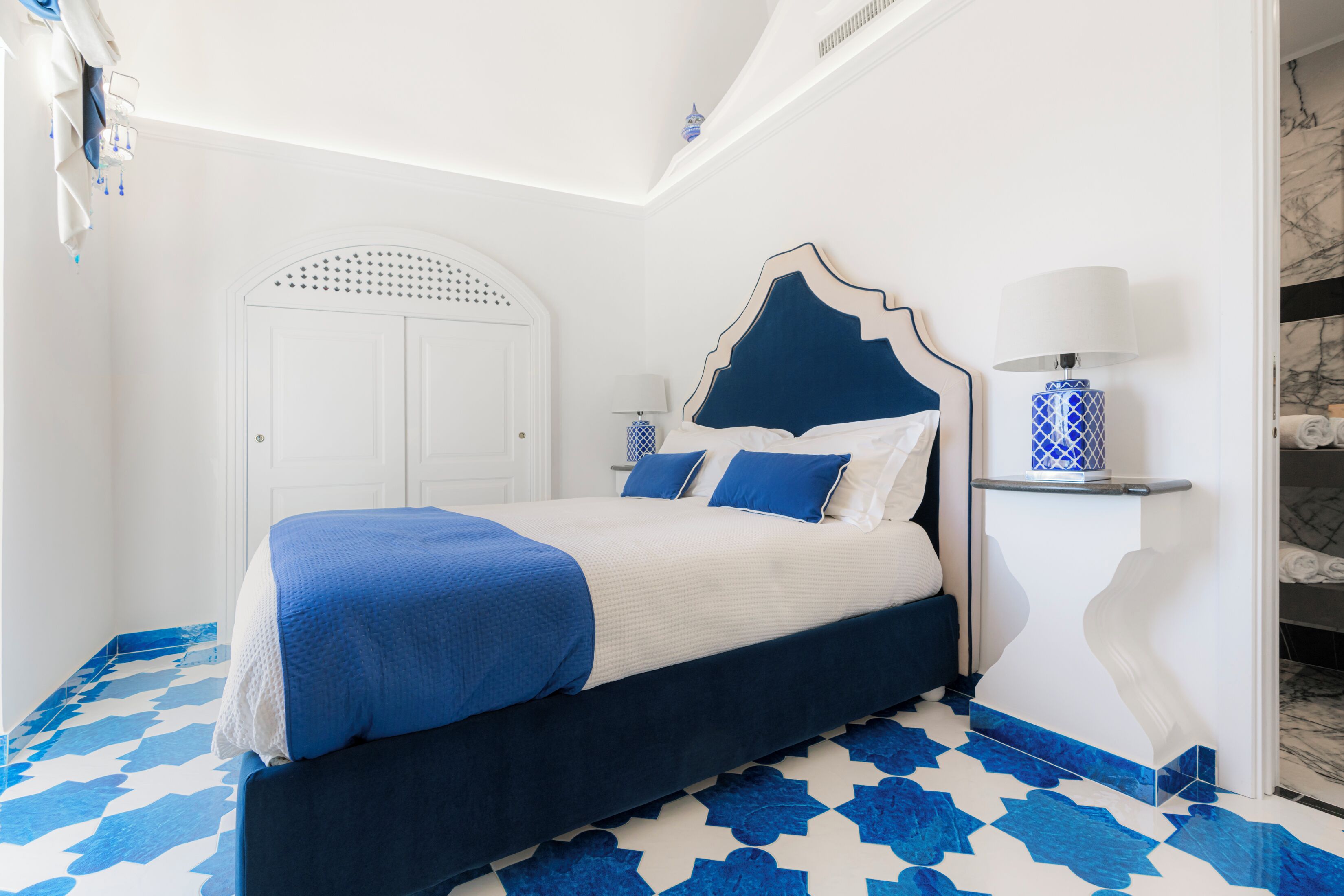 Un dormitorio con cama, mesita de noche y lámpara.
