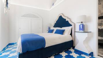 Un dormitorio con cama, mesita de noche y lámpara.