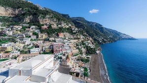 A coastal town with buildings along the cliffside, a beach, and the sea. - King Apartment - Positano Center (Positano)