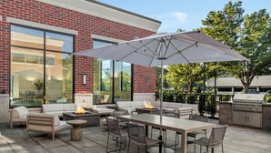 Une terrasse extérieure avec un foyer, des sièges et un barbecue.