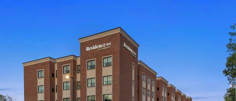 A multi-story brick building with the sign "Residence Inn by Marriott" on the facade.