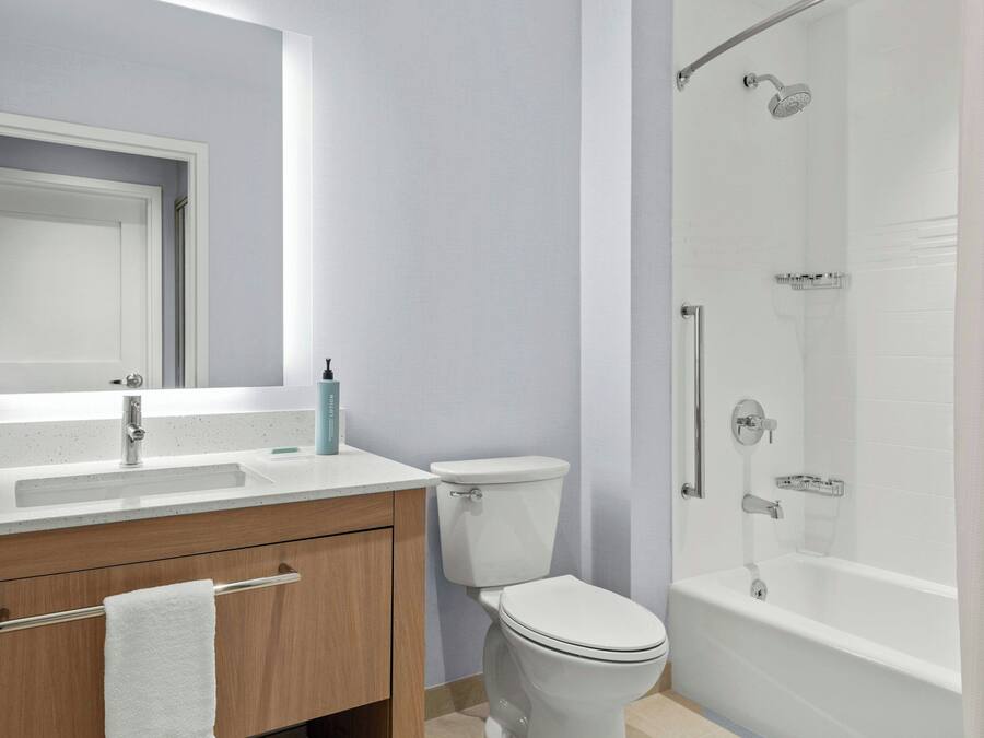 Een moderne badkamer met een wit wastafelmeubel, toilet en bad.