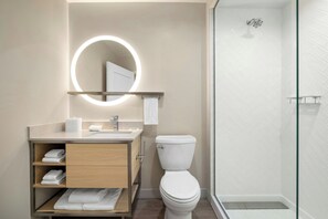 Ein modernes Badezimmer mit Toilette, Waschbecken und Dusche.