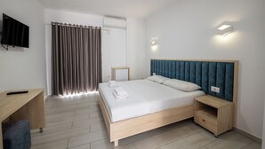Une chambre moderne avec un lit en bois, un bureau, une télévision et un rideau.