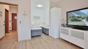 Un dormitorio moderno con una cama, un televisor y un armario.