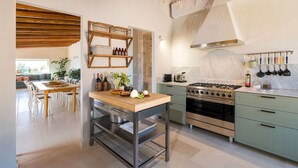 Une cuisine moderne dotée d’un îlot central, d’une cuisinière et d’un coin repas avec une table et des chaises.