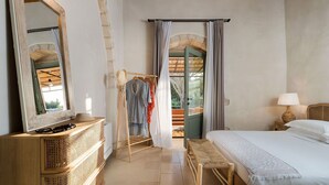 Une chambre à coucher comprenant un lit, une table de chevet, un miroir, une armoire et une vue sur l’extérieur.