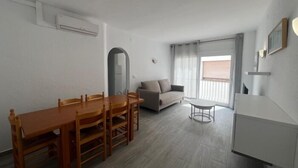 Een moderne woonkamer met een eethoek, een bank en een kleine tafel.
