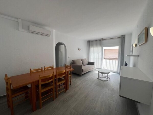 A compact living space with a dining area, a sofa, and a small table.