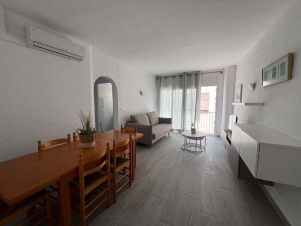 A modern living room with a dining area, a sofa, and a small table. - Lovely flat in the centre of Rosas AV-79 (ROSES)