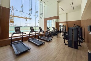 A gym with treadmills, exercise bikes, and weight machines.