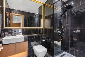 A modern bathroom with a glass-enclosed shower, a wooden vanity, and a large mirror.