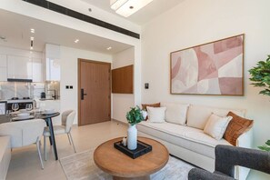 A modern living room with a sofa, coffee table, and dining area.