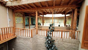 Un patio cubierto con vigas de madera, pared de piedra y un mapa en la pared.