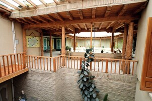 Un patio cubierto con vigas de madera, pared de piedra y un mapa en la pared.