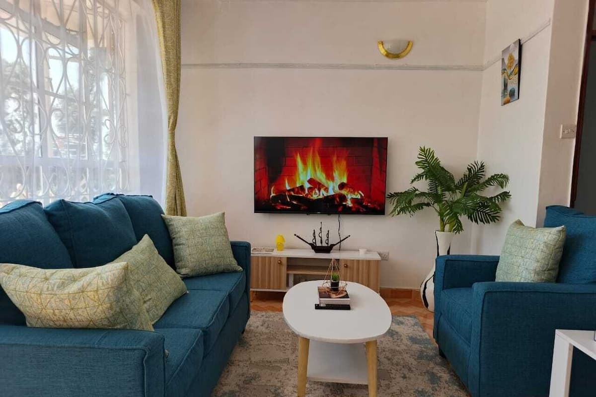 Departamento familiar, vista a la ciudad | Área de sala de estar | Smart TV de 24 pulgadas con canales digitales