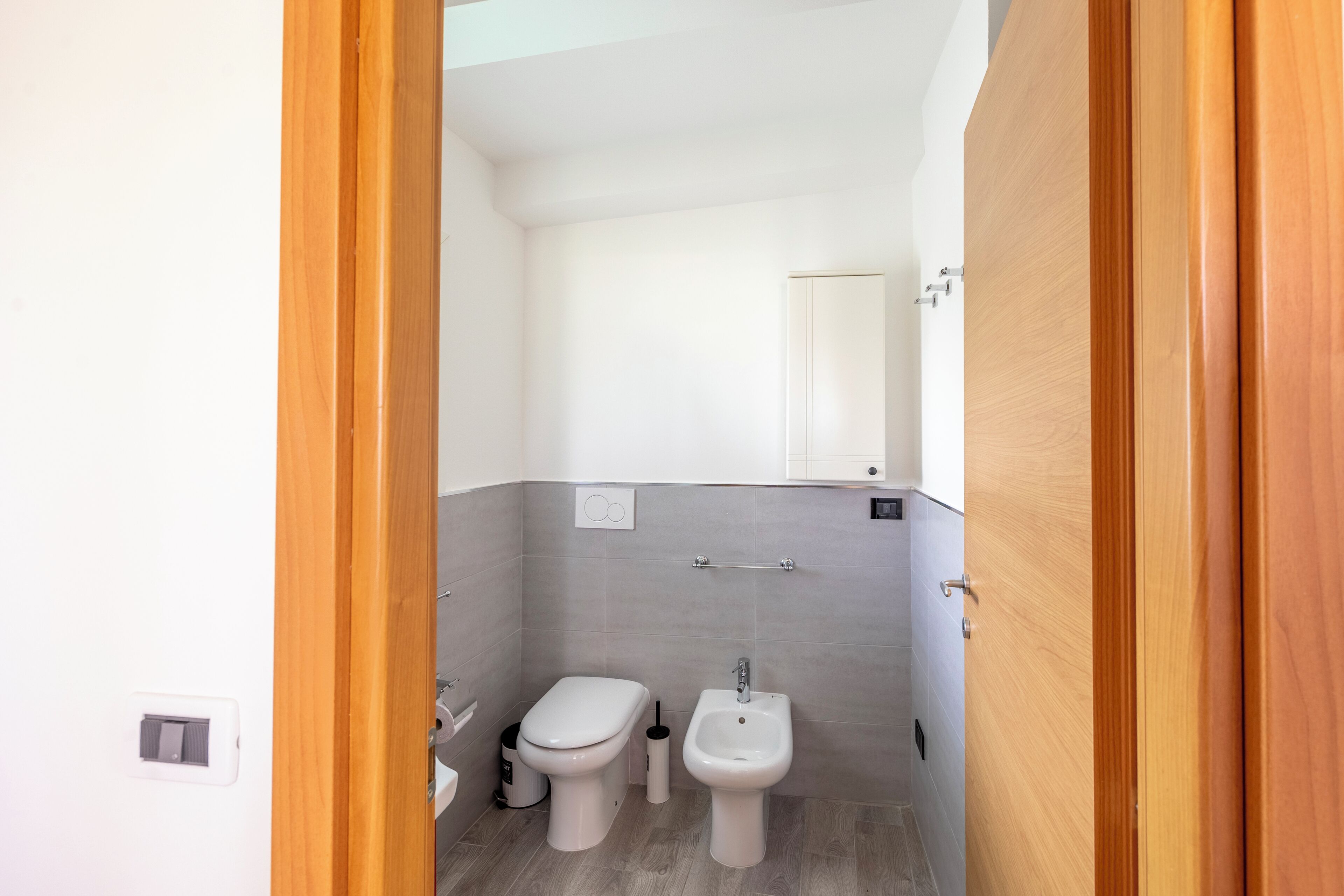 Un baño pequeño con inodoro, bidé y espejo.