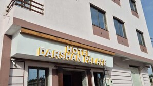 Un hotel llamado Darshan Palace con una zona de recepción y una escalera que conduce a la entrada.