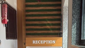 Un área de recepción con un mostrador de madera y un letrero que dice 'RECEPTION'.